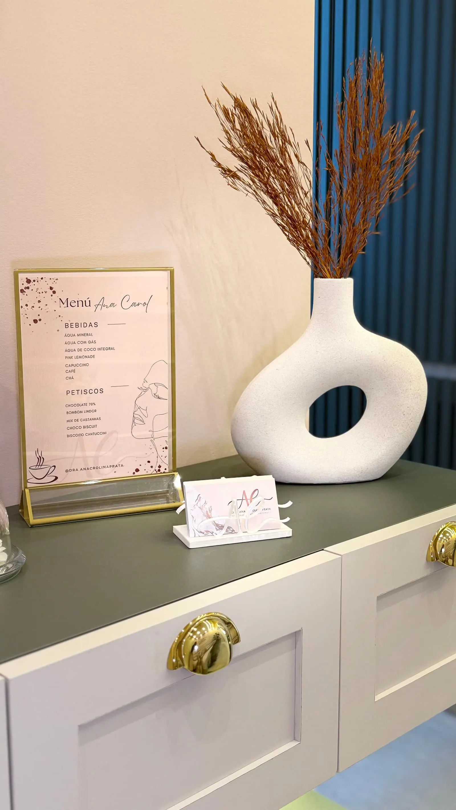 Menu de cortesia da clínica sobre o balcão, ao lado de vaso decorativo
